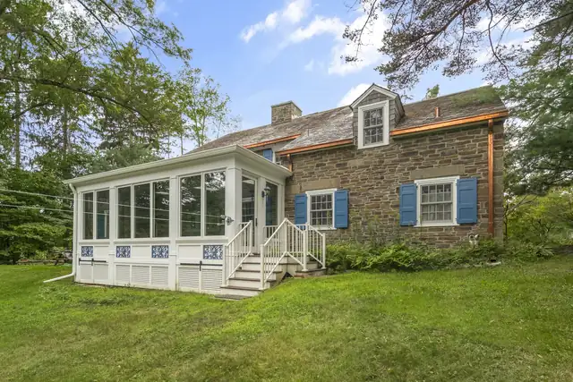 Three-season room addition on a stone house in the Cayuga Heights neighborhood of Ithaca, NY