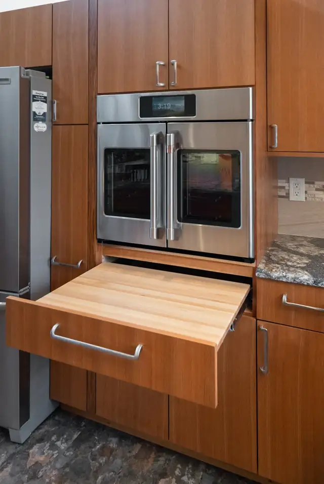 Trumansburg, NY kitchen with a pull-out butcher block shelf under a wall oven in wood cabinetry
