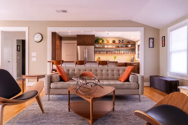 Open living room and kitchen with mid-century furniture, wood cabinetry and open shelving